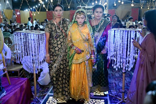 A Pakistani Hindu bride (C) arrives to get married during a mass marriage ceremony organised by the Cutchi Maheshwari Welfare Association in Karachi on May 8, 2026. (Photo by Rizwan TABASSUM / AFP)