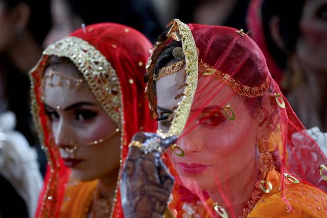 Pakistani Hindu brides look on during a mass marriage ceremony organised by the Cutchi Maheshwari Welfare Association in Karachi on May 8, 2026. (Photo by Rizwan TABASSUM / AFP)