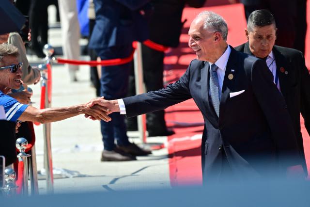 Honduras' President Nasry Asfura greets a man as he arrives for the inauguration ceremony of Costa Rica's president-elect Laura Fernandez, at the National Stadium in San Jose, on May 8, 2026. (Photo by MARTIN BERNETTI / AFP)