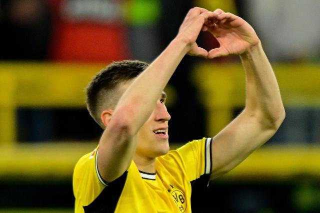 Dortmund's German defender #04 Nico Schlotterbeck makes the love heart gesture to fans as he celebrates scoring the 2-1 goal during the German first division Bundesliga football match between BVB Borussia Dortmund and Eintracht Frankfurt in Dortmund, western Germany on May 8, 2026. (Photo by INA FASSBENDER / AFP) / DFL REGULATIONS PROHIBIT ANY USE OF PHOTOGRAPHS AS IMAGE SEQUENCES AND/OR QUASI-VIDEO  ALTERNATIVE CROP