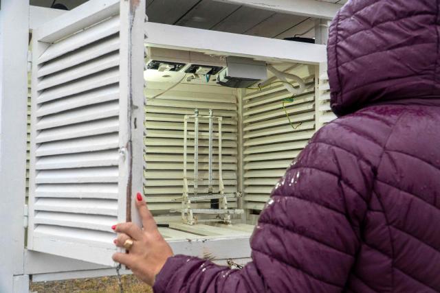 A worker of the Argentine National Meteorological Service (SMN) checks the instrument shelter at the observation field of the meteorological station, next to the Piloto Civil Norberto Fernandez International Airport, in Rio Gallegos, Santa Cruz province, Argentina on May 6, 2026. (Photo by WALTER DIAZ / AFP)