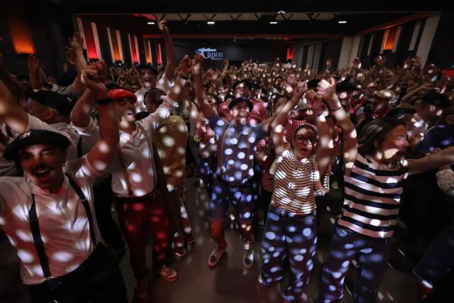 People dance during a big banquet organised by the 'Canon francais' in Montelimar, south-eastern France, on May 8, 2026. The banquets of the 'Canon francais', which draw thousands of guests around roast pork and red wine to "promote local traditions and heritage," are accused by their critics of spreading racist ideas behind their patriotic, typically French image. (Photo by Alex MARTIN / AFP)