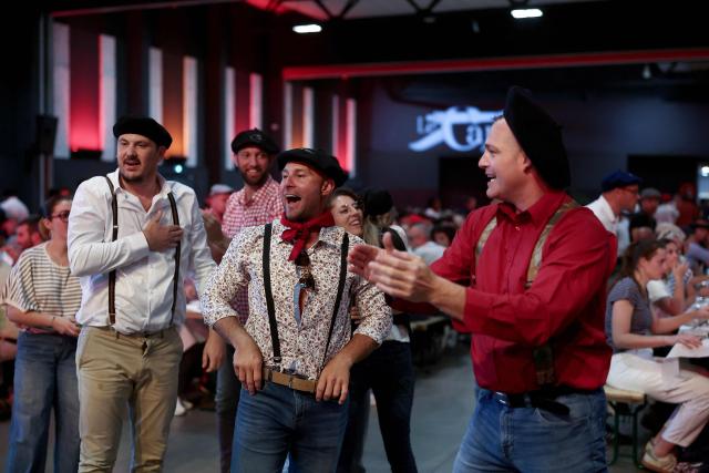 Attendees dance during a big banquet organised by the 'Canon francais' in Montelimar, south-eastern France, on May 8, 2026. The banquets of the 'Canon francais', which draw thousands of guests around roast pork and red wine to "promote local traditions and heritage," are accused by their critics of spreading racist ideas behind their patriotic, typically French image. (Photo by Alex MARTIN / AFP)