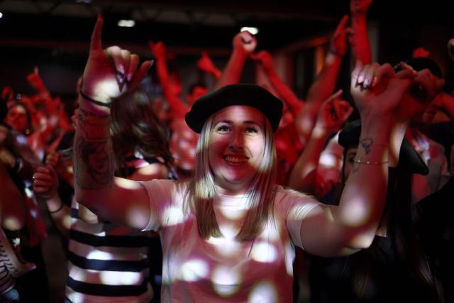 People dance during a big banquet organised by the 'Canon francais' in Montelimar, south-eastern France, on May 8, 2026. The banquets of the 'Canon francais', which draw thousands of guests around roast pork and red wine to "promote local traditions and heritage," are accused by their critics of spreading racist ideas behind their patriotic, typically French image. (Photo by Alex MARTIN / AFP)