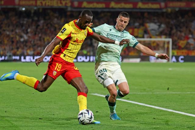 Lens' Senegalese forward #19 Abdallah Sima (L) and Nantes' French defender #24 Frederic Guilbert fight for the ball during the French L1 football match between RC Lens and FC Nantes at the Stade Bollaert-Delelis stadium in Lens on May 8, 2026. (Photo by Francois LO PRESTI / AFP)