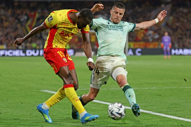 Lens' Senegalese forward #19 Abdallah Sima (L) and Nantes' French defender #24 Frederic Guilbert fight for the ball during the French L1 football match between RC Lens and FC Nantes at the Stade Bollaert-Delelis stadium in Lens on May 8, 2026. (Photo by Francois LO PRESTI / AFP)