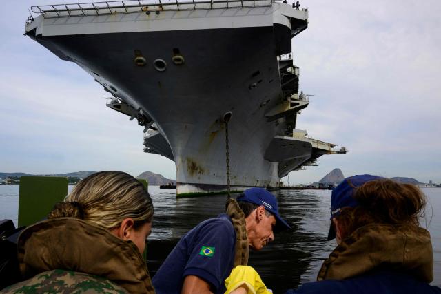 Members of Brazil's Naval Secretariat for Nuclear Safety and Quality collect water samples near the USS Nimitz (CVN-68) aircraft carrier as part of a safety protocol carried out whenever nuclear-powered naval vessels operate or visit the Brazilian coast, in Guanabara Bay in Rio de Janeiro, Brazil, on May 8, 2026. (Photo by Pablo PORCIUNCULA / AFP)