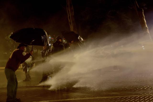 Demonstrators are sprayed with water from a riot police water cannon truck during an anti-government protest in Tirana on May 8, 2026. (Photo by Adnan Beci / AFP)