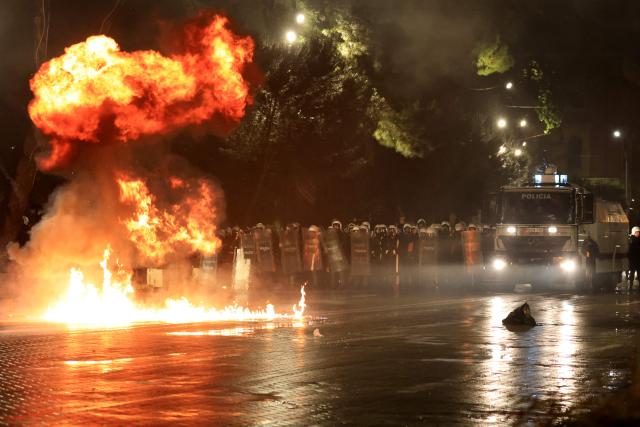 Molotov cocktails explode in front of police officers during an anti-government protest in Tirana on May 8, 2026. (Photo by Adnan Beci / AFP)