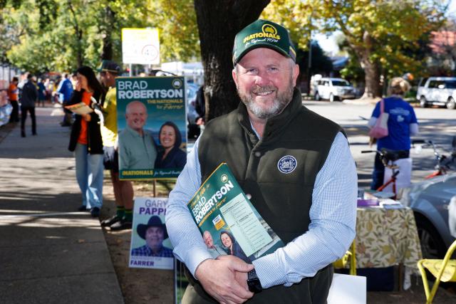 The National Party's candidate Brad Roberston poses for a photo as he campaigns outside Albury Primary School during the Farrer By-Election in Albury, New South Wales on May 9, 2026. (Photo by HILARY WARDHAUGH / AFP)