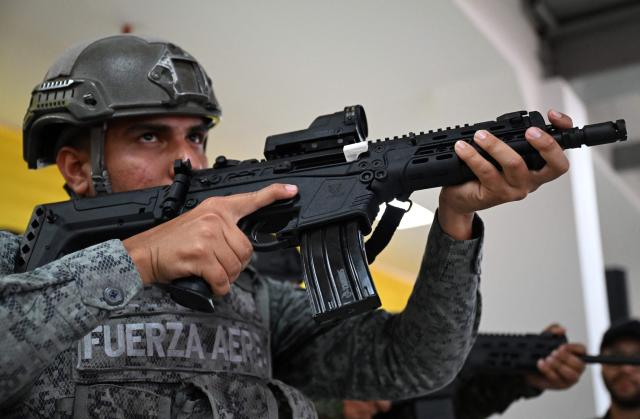 A Colombian soldier poses with a new Jaguar rifle at Indumil's General Jose Maria Cordova arms and ammunition factory in the Soacha municipality, near Bogota, on May 8, 2026. (Photo by Raul ARBOLEDA / AFP)
