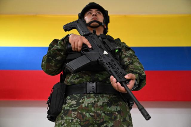 A Colombian soldier poses with a new Jaguar rifle at Indumil's General Jose Maria Cordova arms and ammunition factory in the Soacha municipality, near Bogota, on May 8, 2026. (Photo by Raul ARBOLEDA / AFP)