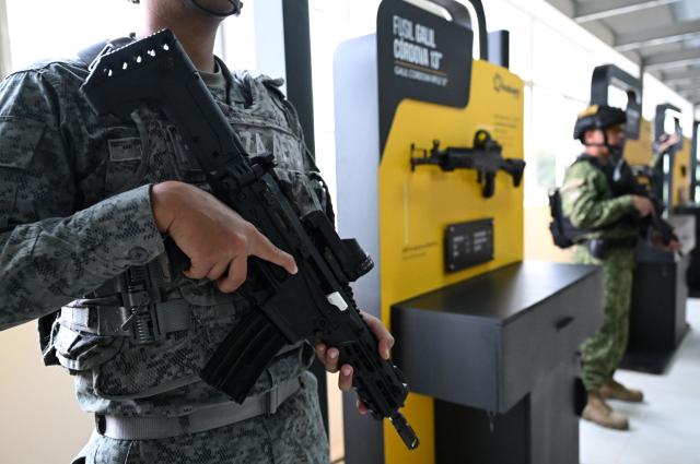 A Colombian soldier poses with a new Jaguar rifle at Indumil's General Jose Maria Cordova arms and ammunition factory in the Soacha municipality, near Bogota, on May 8, 2026. (Photo by Raul ARBOLEDA / AFP)
