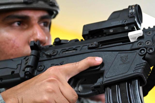 A Colombian soldier poses with a new Jaguar rifle at Indumil's General Jose Maria Cordova arms and ammunition factory in the Soacha municipality, near Bogota, on May 8, 2026. (Photo by Raul ARBOLEDA / AFP)
