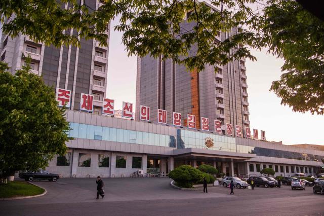 A pedestrian walks past a building adorned with the slogan "Long live Kim Jong Un, the Sun of Juche Korea!" in Pyongyang on May 8, 2026. (Photo by KIM Won Jin / AFP)