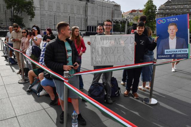 Spectators hold placards as they await arrivals of politicians at Kossuth Square for the inaugural session of the new Parliament and the ceremonial swearing in of representatives in Budapest on May 9, 2026. Hungarian parliament's inaugural session on May 9, 2026, will see a record number of women, accounting for more than a quarter of lawmakers, and more than a hundred deputies new to politics. (Photo by Ferenc ISZA / AFP)