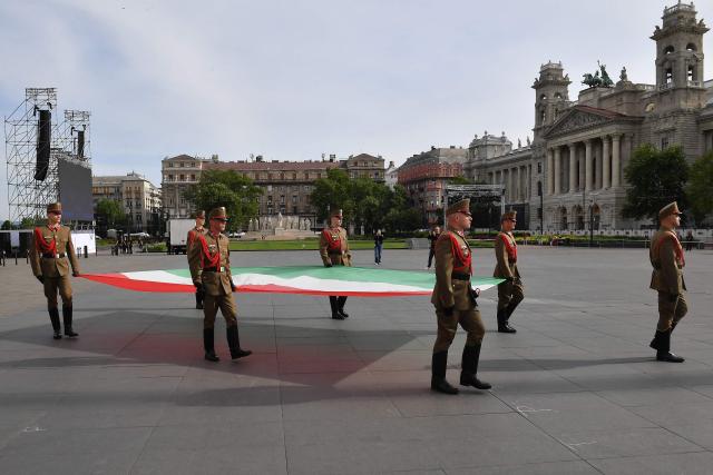 Honour guards carry a Hungarian flag ahead of the arrivals of politicians at Kossuth Square for the inaugural session of the new Parliament and the ceremonial swearing in of representatives in Budapest on May 9, 2026. Hungarian parliament's inaugural session on May 9, 2026, will see a record number of women, accounting for more than a quarter of lawmakers, and more than a hundred deputies new to politics. (Photo by Ferenc ISZA / AFP)