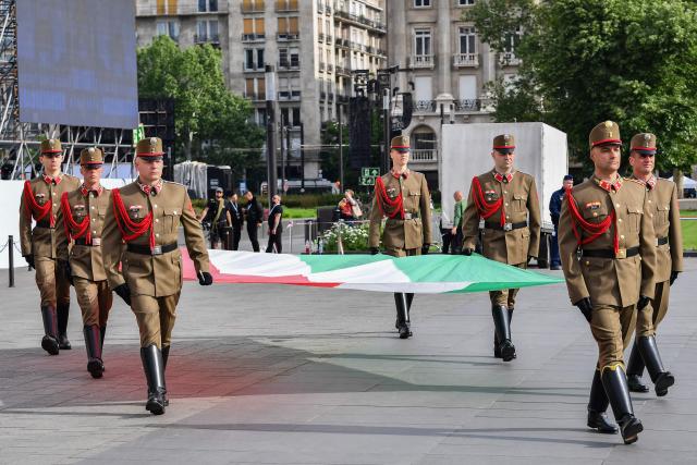 Honour guards carry a Hungarian flag ahead of the arrivals of politicians at Kossuth Square for the inaugural session of the new Parliament and the ceremonial swearing in of representatives in Budapest on May 9, 2026. Hungarian parliament's inaugural session on May 9, 2026, will see a record number of women, accounting for more than a quarter of lawmakers, and more than a hundred deputies new to politics. (Photo by Ferenc ISZA / AFP)