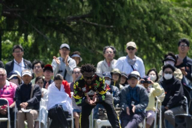 Fans look on as Vanuatu’s Patrick Matautaava fields the ball during the ICC T20 World Cup East Asia-Pacific Qualifier cricket match between Japan and Vanuatu at the Nisshin Cricket Ground at Korogi Sports Park in Nisshin, Aichi Prefecture on May 9, 2026. (Photo by ANDREW CABALLERO-REYNOLDS / AFP)