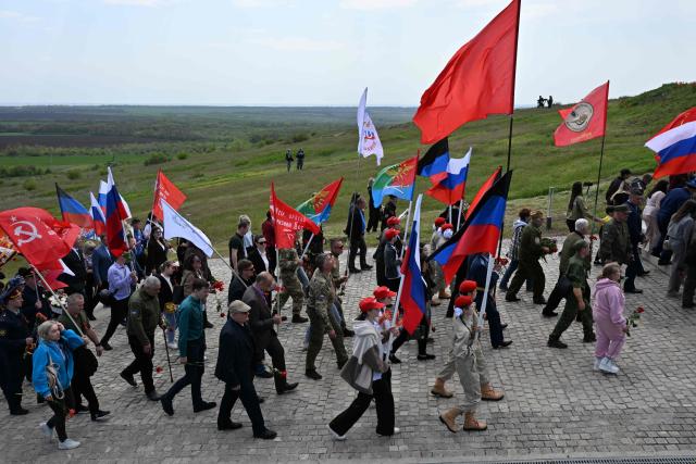 People attend a ceremony marking the 81st anniversary of the victory over Nazi Germany in World War II at the Savur-Mohyla memorial in the Donetsk region, Russian-controlled Ukraine on May 8, 2026, amid the ongoing Russian-Ukrainian conflict. (Photo by AFP)