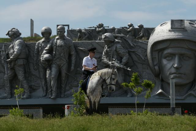 A Russian police officer rides a horse past a monument during a ceremony marking the 81st anniversary of the victory over Nazi Germany in World War II at the Savur-Mohyla memorial in the Donetsk region, Russian-controlled Ukraine on May 8, 2026, amid the ongoing Russian-Ukrainian conflict. (Photo by AFP)