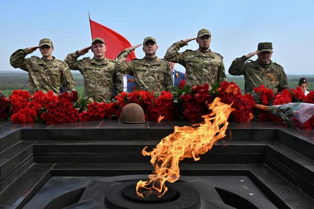 Russian servicemen pay their respect at the Eternal Flame during a ceremony marking the 81st anniversary of the victory over Nazi Germany in World War II at the Savur-Mohyla memorial in the Donetsk region, Russian-controlled Ukraine on May 8, 2026, amid the ongoing Russian-Ukrainian conflict. (Photo by AFP)