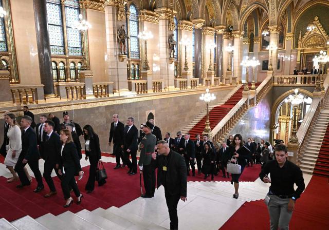 Hungarian politicians walk up stairs as they arrive at the Parliament building for the inaugural session of the new Parliament and the ceremonial swearing in of representatives in Budapest on May 9, 2026. Hungarian parliament's inaugural session on May 9, 2026, will see a record number of women, accounting for more than a quarter of lawmakers, and more than a hundred deputies new to politics. (Photo by Attila KISBENEDEK / AFP)