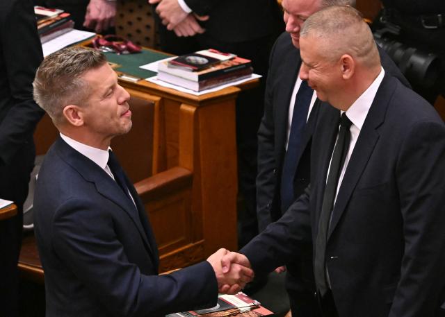 Hungary's incoming Prime Minister Peter Magyar (L) shakes hands with Hungary's designated Defence Minister Romulusz Ruszin-Szendi as he arrives ahead of his official swear-in ceremony at the Hungarian parliament in Budapest on May 9, 2026. Pro-European conservative Peter Magyar will be officially sworn in as Prime Minister by the Hungarian parliament on May 9, 2026, just under a month after his landslide victory in the parliamentary elections against nationalist Viktor Orban. Hungarian parliament's inaugural session on May 9, 2026, will see a record number of women, accounting for more than a quarter of lawmakers, and more than a hundred deputies new to politics. (Photo by Attila KISBENEDEK / AFP)