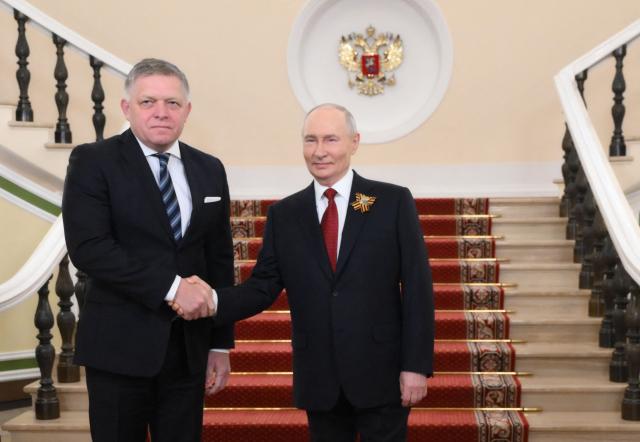 In this pool photograph distributed by the Russian state agency Sputnik, Russia's President Vladimir Putin welcomes Slovak Prime Minister Robert Fico prior to the Victory Day military parade, at the Kremlin in Moscow on May 9, 2026. Russia celebrates the 81st anniversary of the Soviet Union's victory over Nazi Germany in World War Two (WWII). (Photo by Grigory SYSOYEV / POOL / AFP)