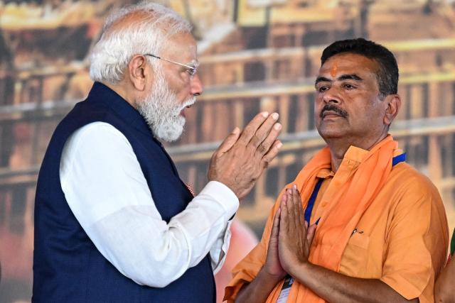 Newly elected Chief Minister of India's West Bengal state, Suvendu Adhikari (R) greets India's Prime Minister Narendra Modi after taking an oath during his swearing-in ceremony in Kolkata on May 9, 2026. (Photo by Dibyangshu SARKAR / AFP)