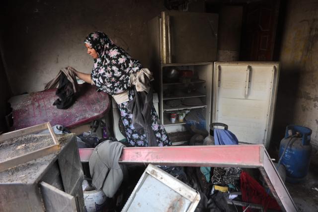 A Palestinian woman looks for her belongings inside a damaged building, a day after of an Israeli strike at the Shati refugee camp (Beach) in Gaza City, on May 9, 2026. Despite an October ceasefire, Gaza remains gripped by daily violence as Israeli strikes continue, with both the military and Hamas accusing one another of violating the truce. (Photo by Omar AL-QATTAA / AFP)