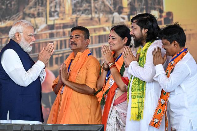 TOPSHOT - India's Prime Minister Narendra Modi (L) greets Suvendu Adhikari (2L), newly elected Chief Minister of West Bengal state, and cabinet ministers during a swearing-in ceremony in Kolkata on May 9, 2026. (Photo by Dibyangshu SARKAR / AFP)