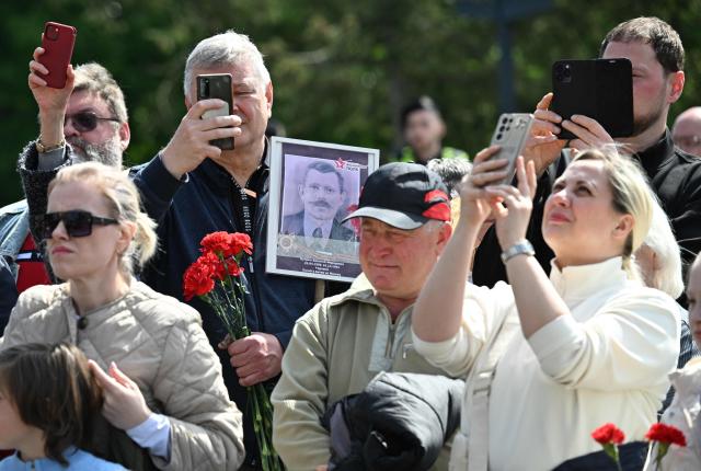 People use their mobile phones to take pictures as they pay their respect at the Soviet War Memorial Tiergarten in Berlin on May 9, 2026, during an event to mark the 81st anniversary of the 1945 victory against Nazi Germany. (Photo by RALF HIRSCHBERGER / AFP)
