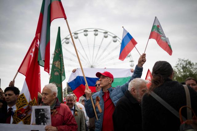 People wave Russian and Bulgarian flags in front of the dismentled Soviet Army monument during a celebration of the Victory Day marking the anniversary of the victory over Nazi Germany during World War II, in Sofia on May 9, 2026. Pro-Russian circles in Bulgaria remain divided over the prospects for improved relations with Russia following Rumen Radev’s assumption of the office of prime minister. (Photo by Nikolay DOYCHINOV / AFP)