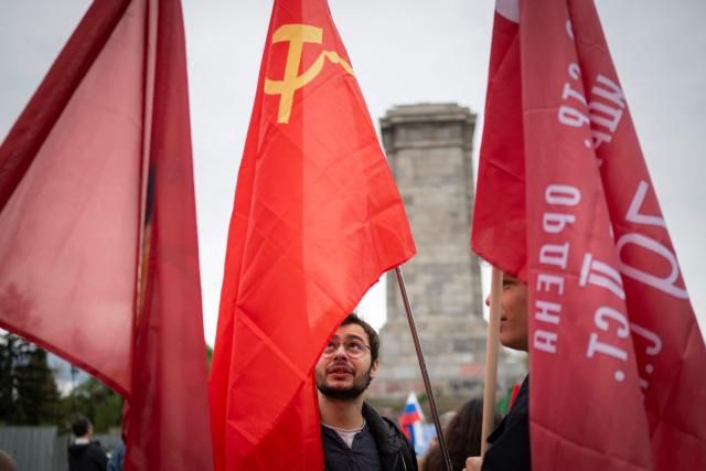 People wave Soviet Union flags in front of the dismentled Soviet Army monument during a celebration of the Victory Day marking the anniversary of the victory over Nazi Germany during World War II, in Sofia on May 9, 2026. Pro-Russian circles in Bulgaria remain divided over the prospects for improved relations with Russia following Rumen Radev’s assumption of the office of prime minister. (Photo by Nikolay DOYCHINOV / AFP)