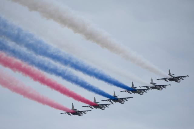 Russian Sukhoi SU-25 fighter jets release smoke in the colours of the Russian tricolor flag as they fly over central Moscow during the Victory Day military parade on May 9, 2026. Russia celebrates the 81st anniversary of the Soviet Union's victory over Nazi Germany in World War Two (WWII). (Photo by Pavel Bednyakov / POOL / AFP)
