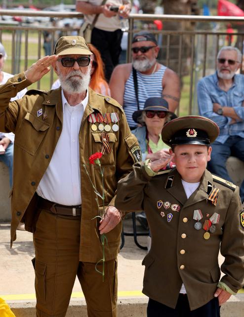 Red Army veterans participate alongside relatives and supporters salute during a ceremony to commemorate the 81th anniversary of the Victory over Germany in World War II, at the Victory Monument commemorating the Red Army's victory over Nazi Germany, in the Israeli coastal city of Netanya on May 9, 2026. (Photo by JACK GUEZ / AFP)