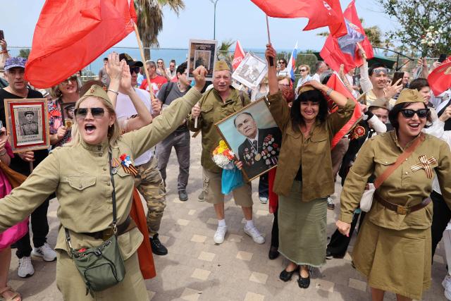 Red Army veterans participate alongside relatives and supporters as they dance during a ceremony to commemorate the 81th anniversary of the Victory over Germany in World War II, at the Victory Monument commemorating the Red Army's victory over Nazi Germany, in the Israeli coastal city of Netanya on May 9, 2026. (Photo by JACK GUEZ / AFP)