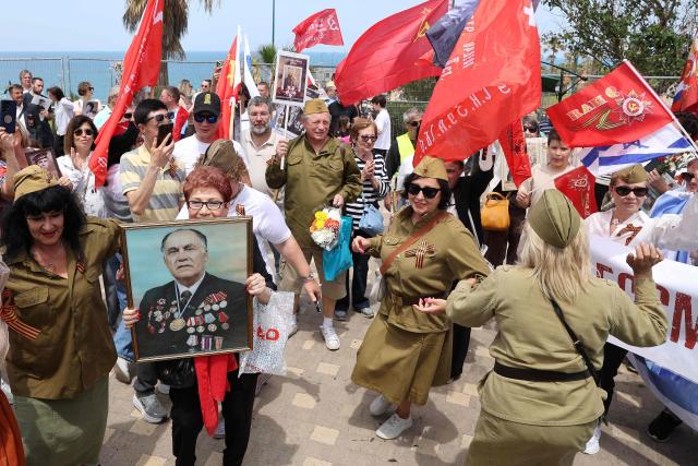 Red Army veterans participate alongside relatives and supporters as they dance during a ceremony to commemorate the 81th anniversary of the Victory over Germany in World War II, at the Victory Monument commemorating the Red Army's victory over Nazi Germany, in the Israeli coastal city of Netanya on May 9, 2026. (Photo by JACK GUEZ / AFP)