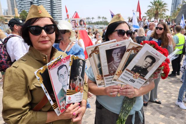 Red Army veterans participate alongside relatives and supporters during a ceremony to commemorate the 81th anniversary of the Victory over Germany in World War II, at the Victory Monument commemorating the Red Army's victory over Nazi Germany, in the Israeli coastal city of Netanya on May 9, 2026. (Photo by JACK GUEZ / AFP)