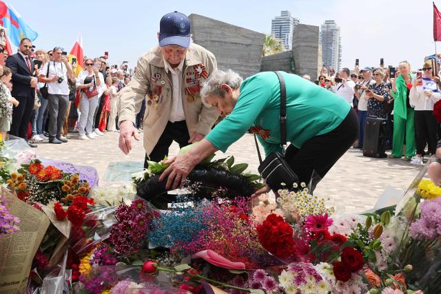 Red Army veterans participate alongside relatives and supporters lay flowers and a wreath during a ceremony to commemorate the 81th anniversary of the Victory over Germany in World War II, at the Victory Monument commemorating the Red Army's victory over Nazi Germany, in the Israeli coastal city of Netanya on May 9, 2026. (Photo by JACK GUEZ / AFP)