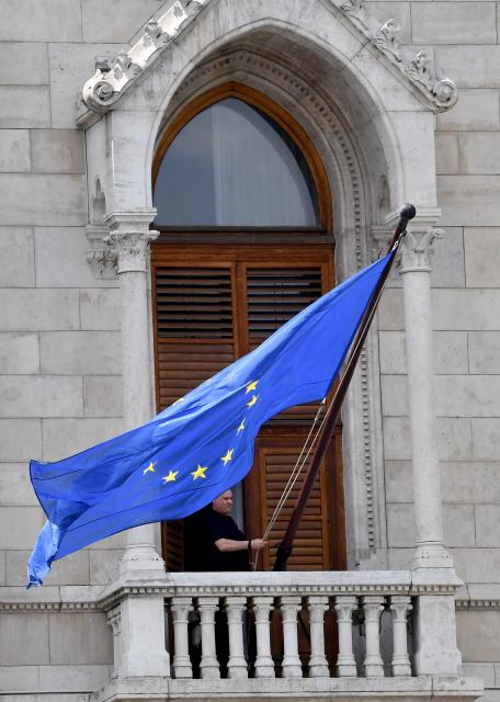 The flag of the European Union (EU) is placed at the building of the Hungarian Parliament, after the newly appointed parliament speaker ordered the EU flag be hung back on the building in Budapest on May 9, 2026, ending the flag's long absence under Viktor Orban, who was voted from power in mid-April 2026. Pro-European conservative Peter Magyar will be officially sworn in as Prime Minister by the Hungarian parliament on May 9, 2026, just under a month after his landslide victory in the parliamentary elections against nationalist Viktor Orban. (Photo by Ferenc ISZA / AFP)