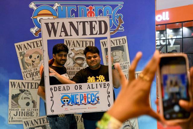 Fans pose behind a display of the Japanese manga and animation series 'One Piece' during the Mumbai Comic Con 2026 festival in Mumbai on May 9, 2026. (Photo by Indranil MUKHERJEE / AFP)