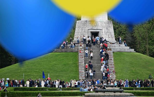 Balloons in the colors of Ukraine are seen as people pay their respect at the Soviet War Memorial Treptow in Berlin on May 9, 2026, during an event to mark the 81st anniversary of the 1945 victory against Nazi Germany. (Photo by RALF HIRSCHBERGER / AFP)