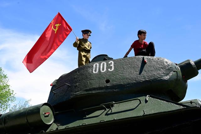 TOPSHOT - Boys play atop a T-34-85 tank during a ceremony marking the 81st anniversary of the victory over Nazi Germany in World War II in Yerevan on May 9, 2026. (Photo by KAREN MINASYAN / AFP)