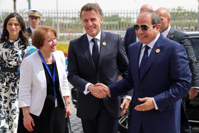 France's President Emmanuel Macron (C) shakes hands with his Egyptian counterpart Abdel Fattah al-Sisi upon his arrival at the Senghor University in Borg el-Arab, near the Mediterranean coastal city of Alexandria on May 9, 2026. (Photo by Ludovic MARIN / AFP)