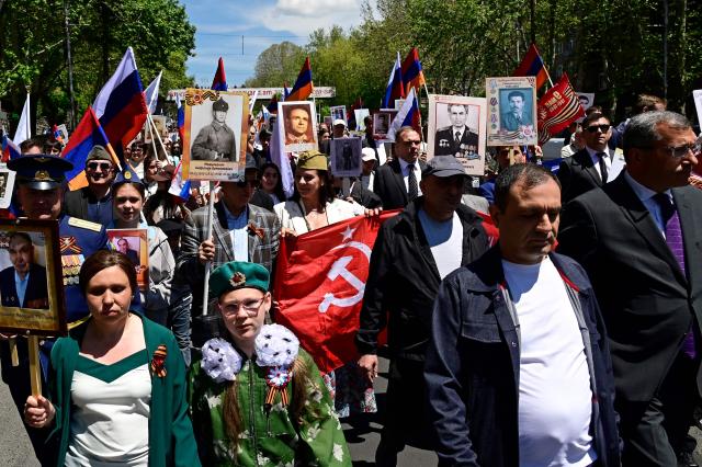 Participants carry portraits of World War Two soldiers during the Immortal Regiment march in Yerevan on May 9, 2026. Armenia celebrates the 81st anniversary of the Allied victory over Nazi Germany in World War II. (Photo by KAREN MINASYAN / AFP)