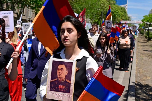 Participants carry portraits of World War Two soldiers during the Immortal Regiment march in Yerevan on May 9, 2026. Armenia celebrates the 81st anniversary of the Allied victory over Nazi Germany in World War II. (Photo by KAREN MINASYAN / AFP)