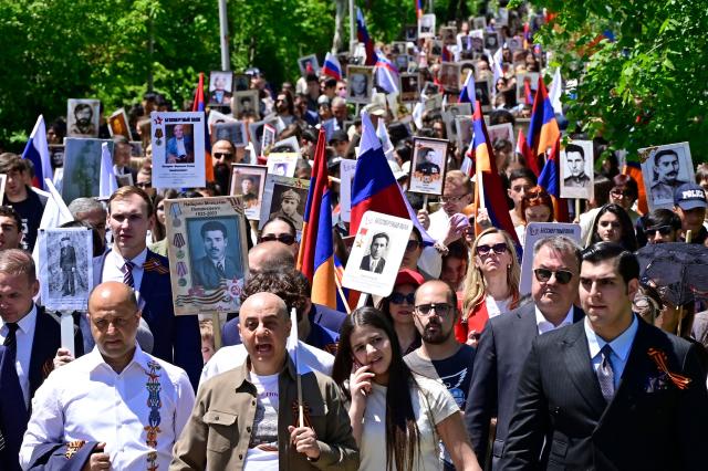 Participants carry portraits of World War Two soldiers during the Immortal Regiment march in Yerevan on May 9, 2026. Armenia celebrates the 81st anniversary of the Allied victory over Nazi Germany in World War II. (Photo by KAREN MINASYAN / AFP)