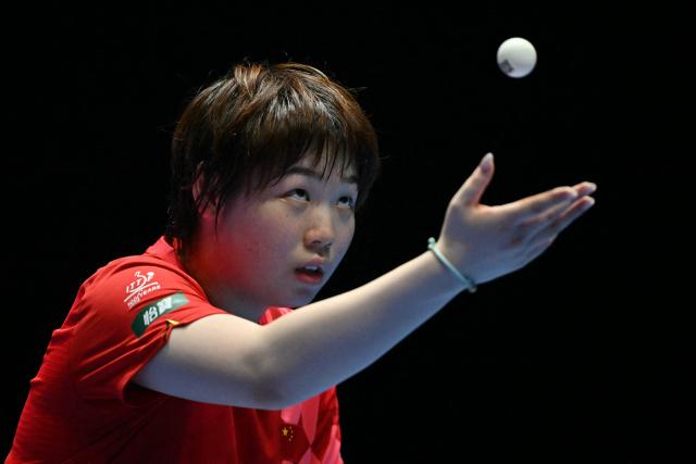 China's Kuai Man serves against Romania's Andreea Dragoman during their Women's Teams semi-final match at the ITTF World Table Tennis Championships in Wembley Arena, west London on May 9, 2026. (Photo by Glyn KIRK / AFP)